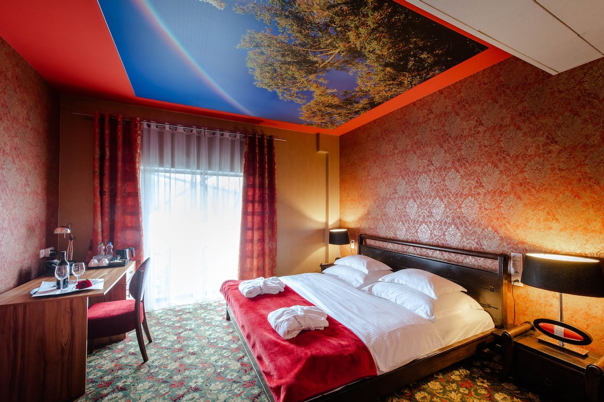 A hotel room with a bed, a desk, and a chair.