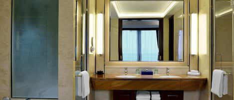 Un baño moderno con dos lavamanos, un espejo grande y una cabina de ducha de vidrio.