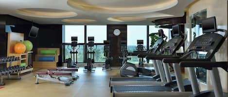 A modern gym with treadmills, weights, and exercise balls.