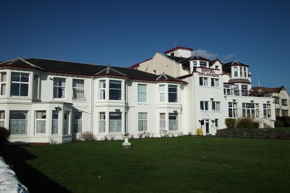 A white building with a sign that reads "Hotel Planade." It has multiple windows and a red roof. - The Esplanade Hotel (Dunoon)