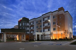 A Courtyard by Marriott hotel with a modern design, multiple floors, and a well-lit entrance.