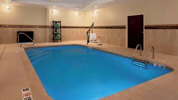 A swimming pool with a 5 ft depth and 15 ft width, surrounded by beige tiled walls and a dark door.