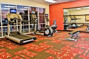 A gym with treadmills, elliptical machines, and a stationary bike.
