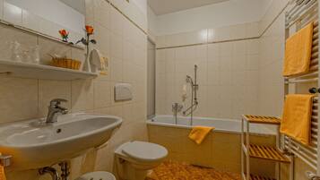 Un baño con lavamanos, inodoro y bañera.