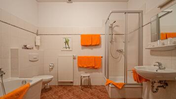 A bathroom with a bathtub, toilet, shower, and sink.