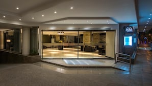 A modern hotel lobby with a glass entrance, a staircase, and a visible restaurant sign. - Neuquen Tower Hotel (Neuquén)