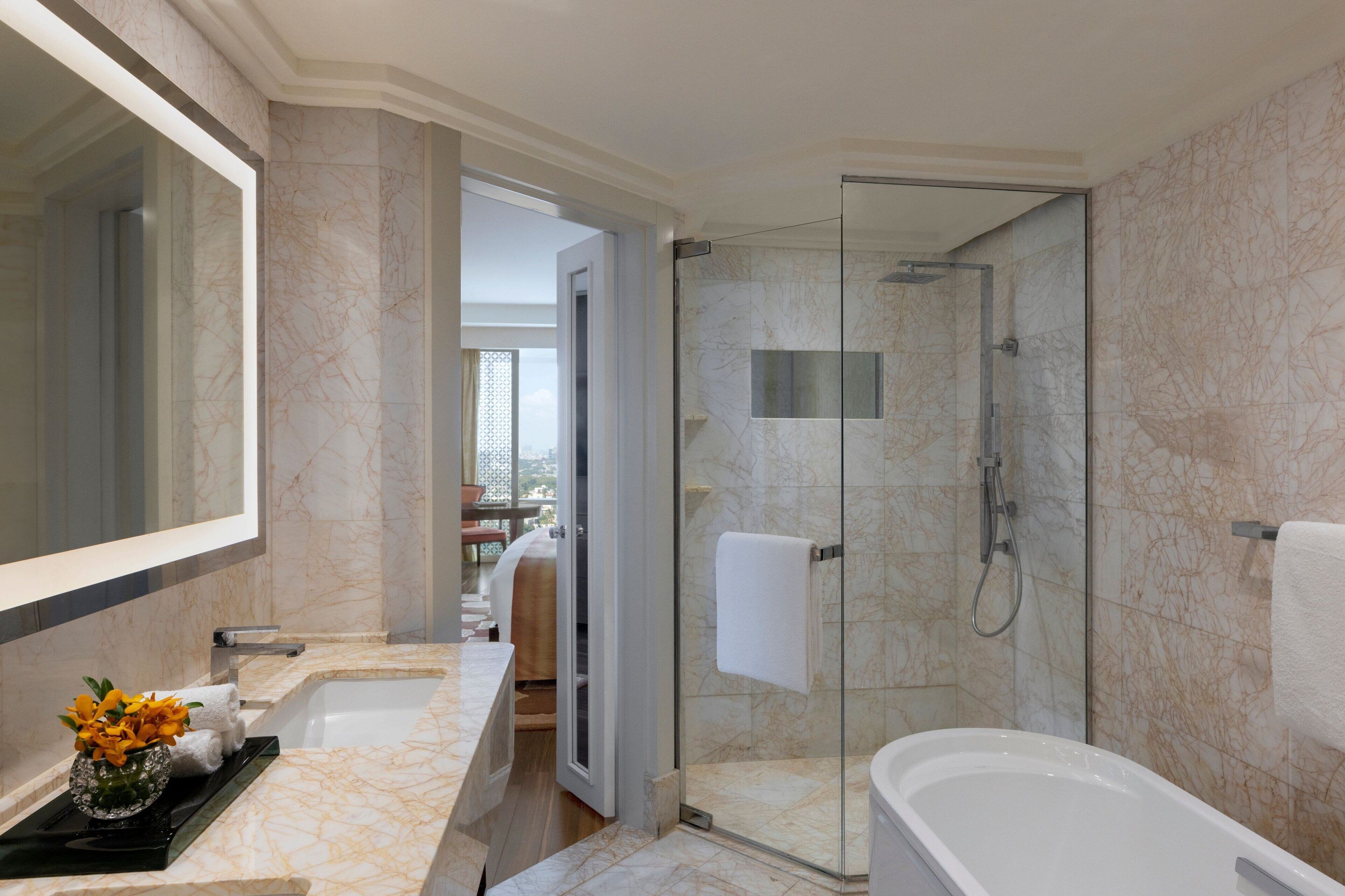 Un baño moderno con ducha de vidrio, un espejo grande y una bañera.