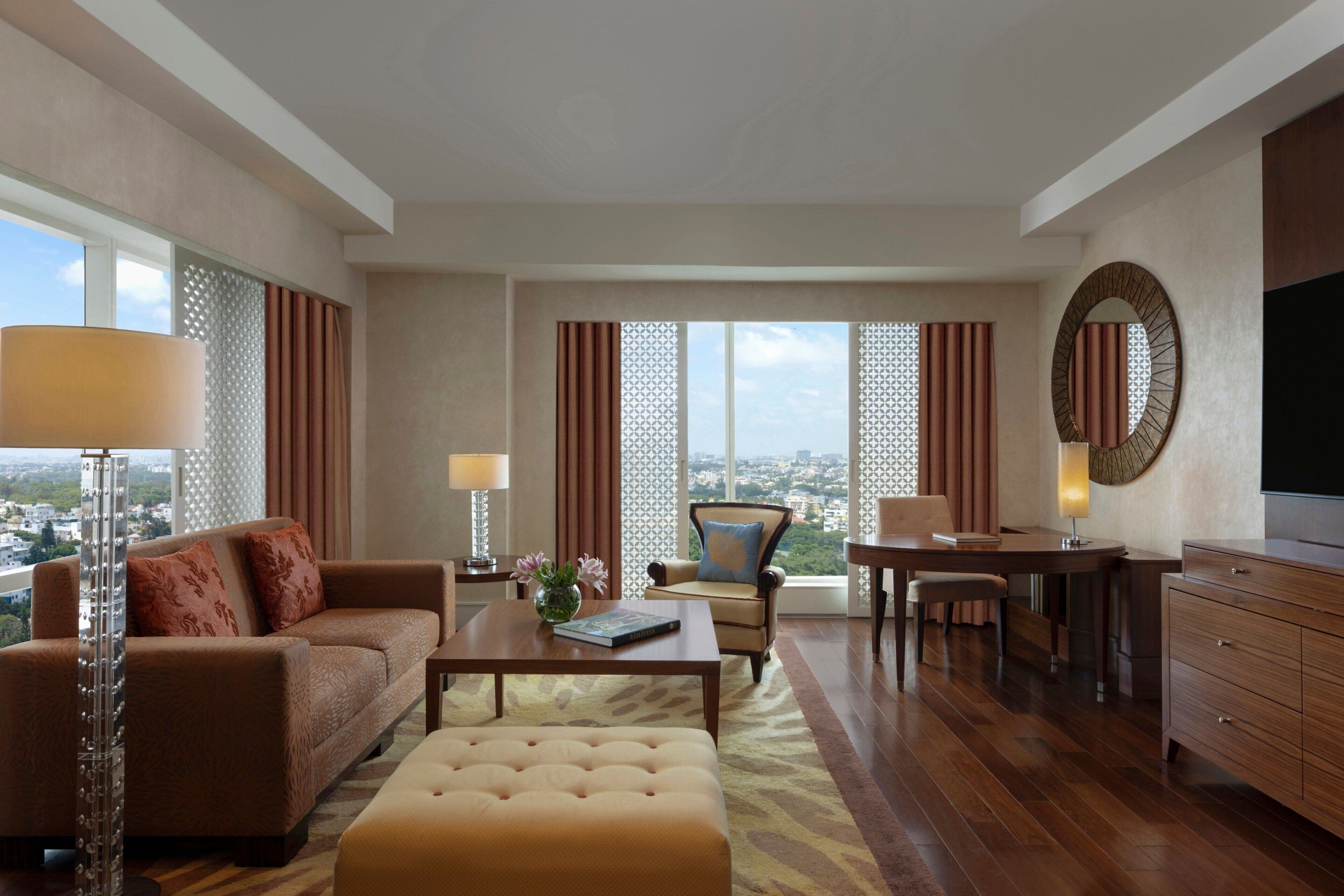 A spacious living room with a sofa, ottoman, coffee table, and a dining area with a chair and table.