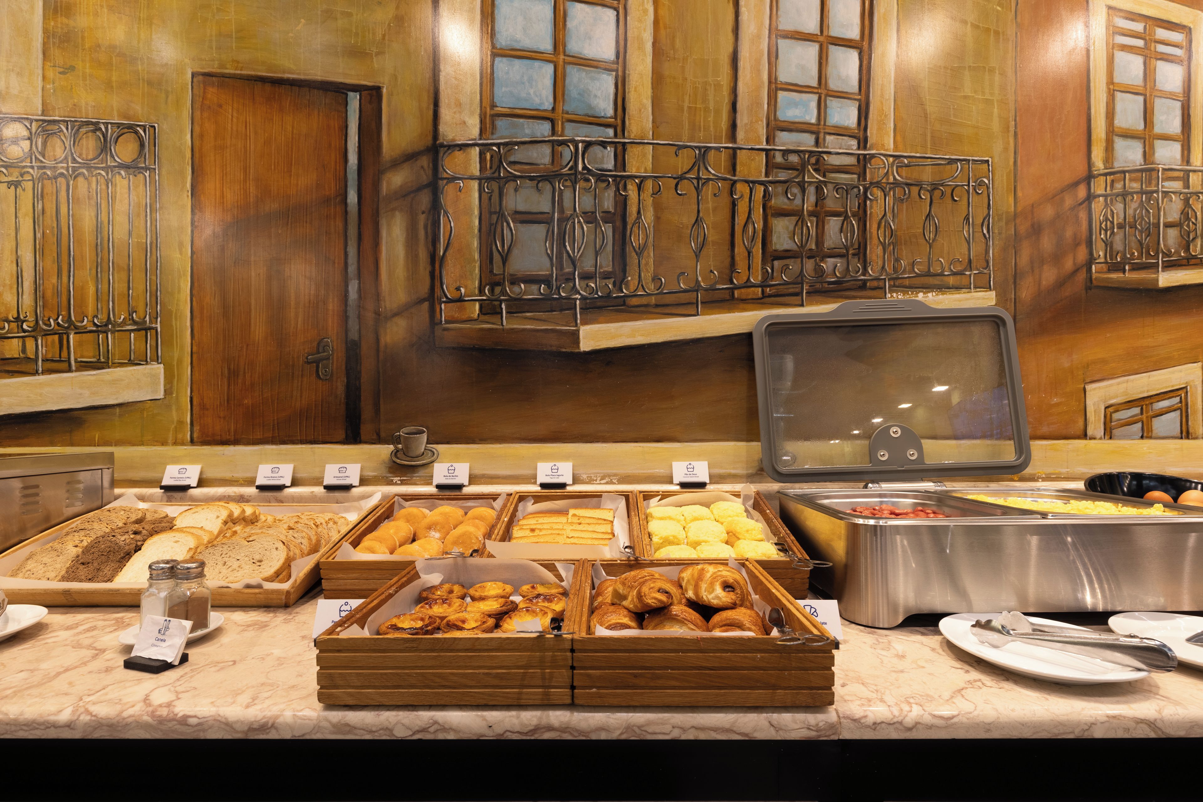 A buffet with various food items, including bread, pastries, and eggs.