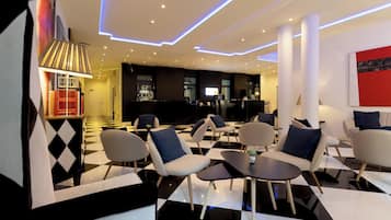 A modern lounge area with checkered flooring, contemporary furniture, and ambient lighting.