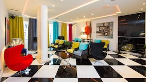 A modern living room with a checkered floor, colorful curtains, and contemporary furniture.