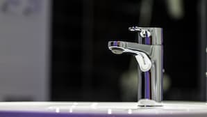 A chrome faucet on a white countertop.
