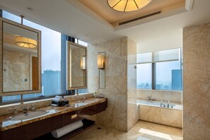 A modern bathroom with a large mirror, two sinks, a bathtub, and a city view.
