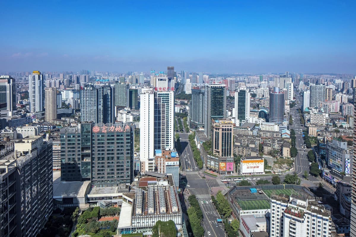 Une vue urbaine avec de hauts immeubles, des routes et un ciel dégagé.