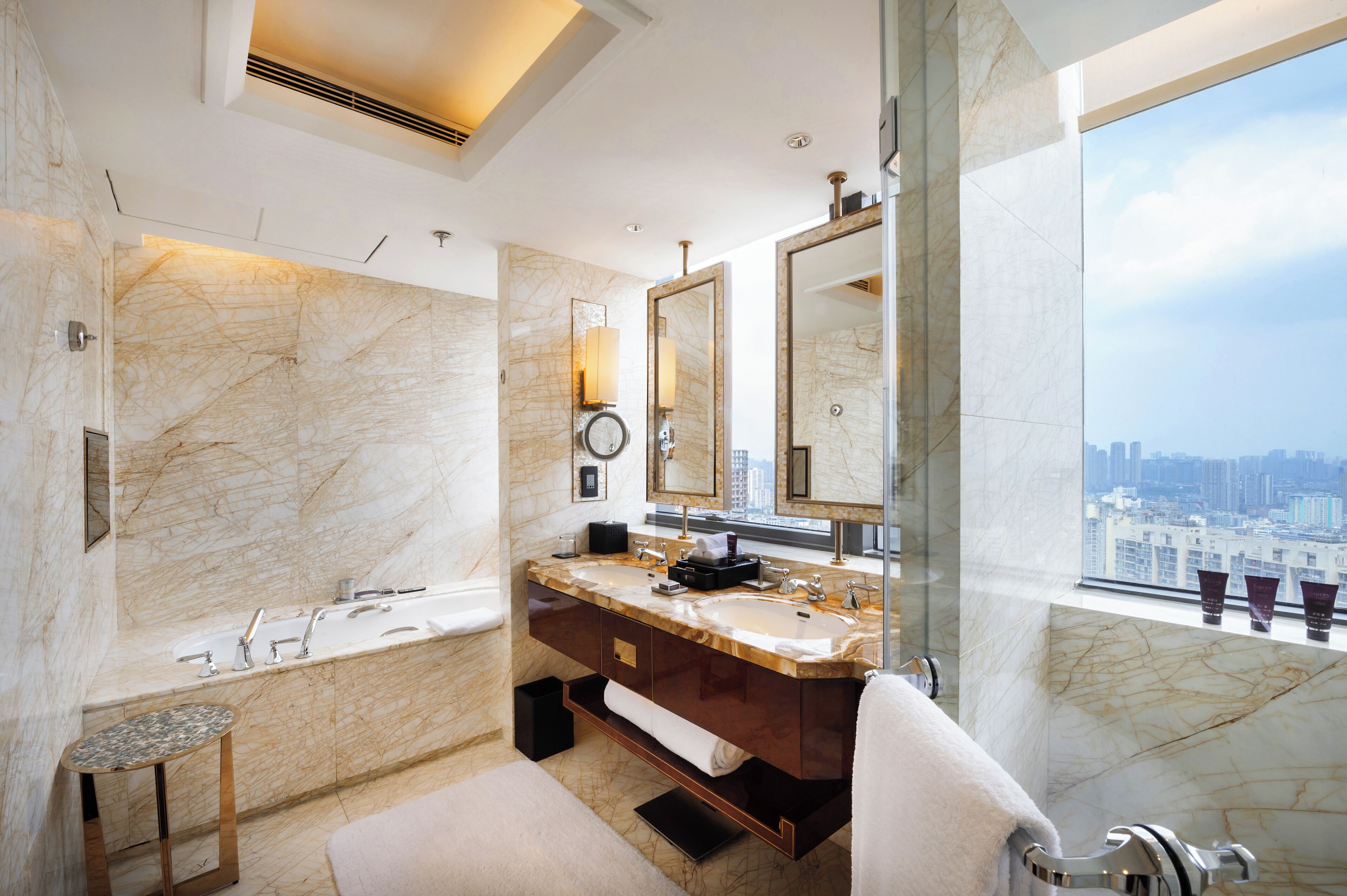 Ein modernes Badezimmer mit einer großen Badewanne, zwei Waschbecken und einem großen Spiegel.