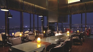 A modern restaurant with high ceilings, large windows, and a city view. - The Ritz-Carlton, Chengdu (Chengdu)
