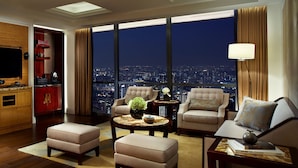 A spacious living room with a city view, a television, and a red minibar. - The Ritz-Carlton, Chengdu (Chengdu)