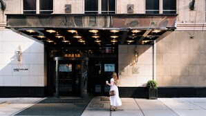 The entrance of WestHouse with a covered entrance, a doormat, and a potted plant on the sidewalk. - WestHouse Hotel New York, an SLH Hotel (New York)