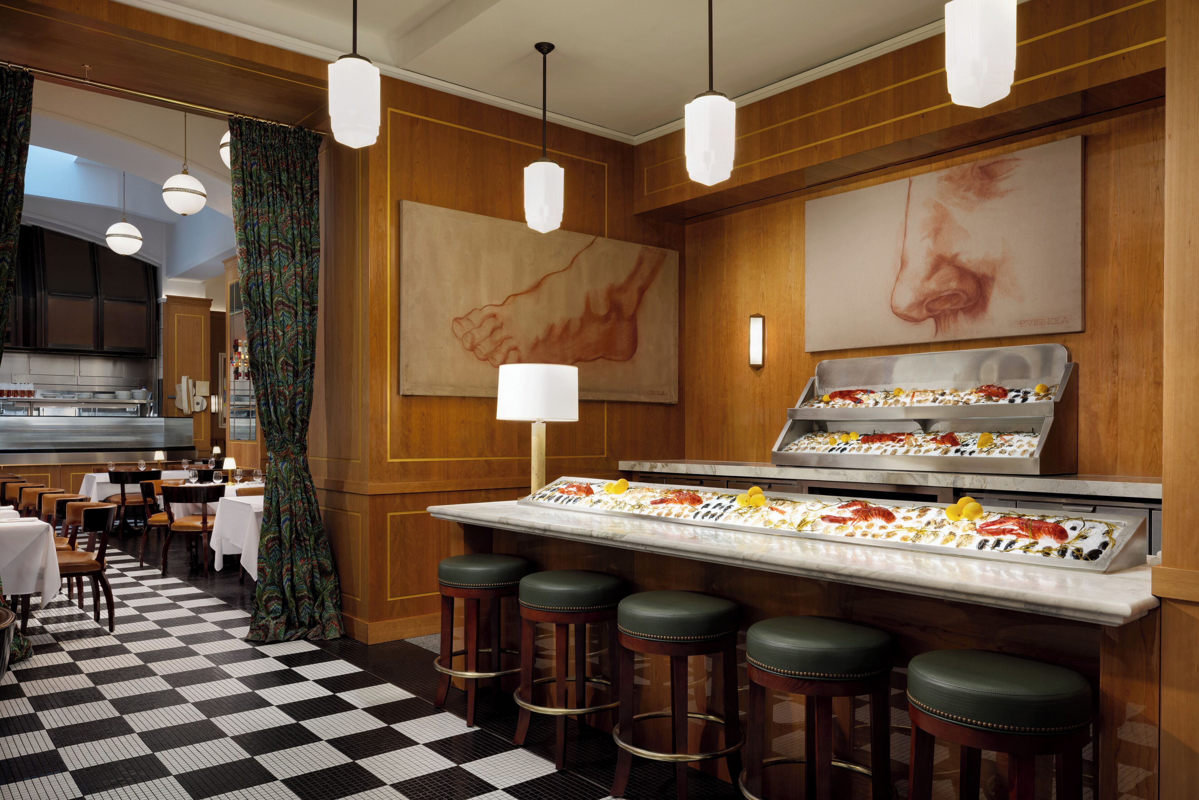 A restaurant with a checkered floor, bar stools, and a display case with food items.