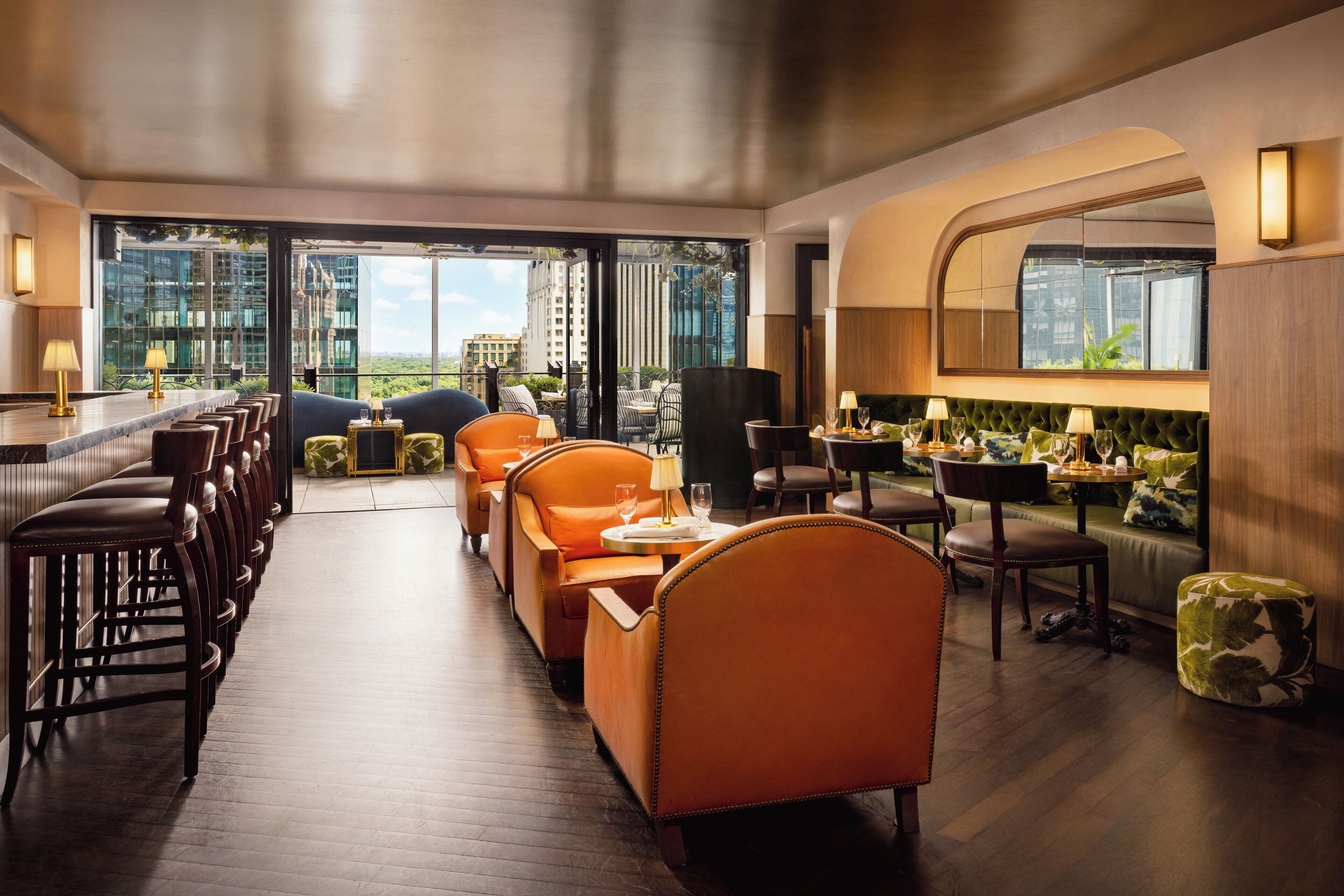 A modern hotel lobby with a bar area, seating, and a view of the cityscape.