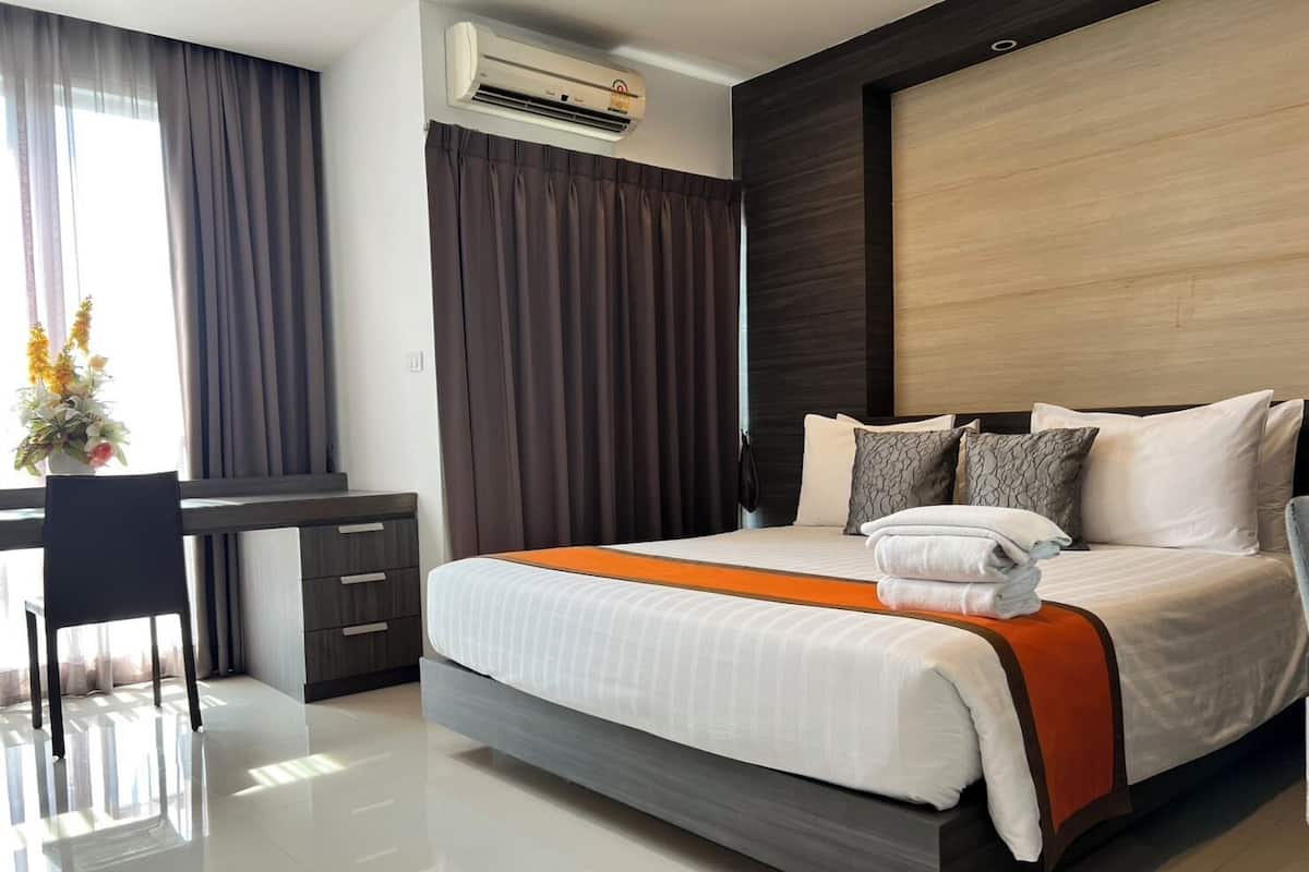 Habitación de hotel moderna con cama, escritorio y aire acondicionado.