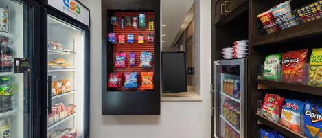 Et hotelkorydor med en snackbod, der tilbyder forskellige snacks og drikkevarer.
