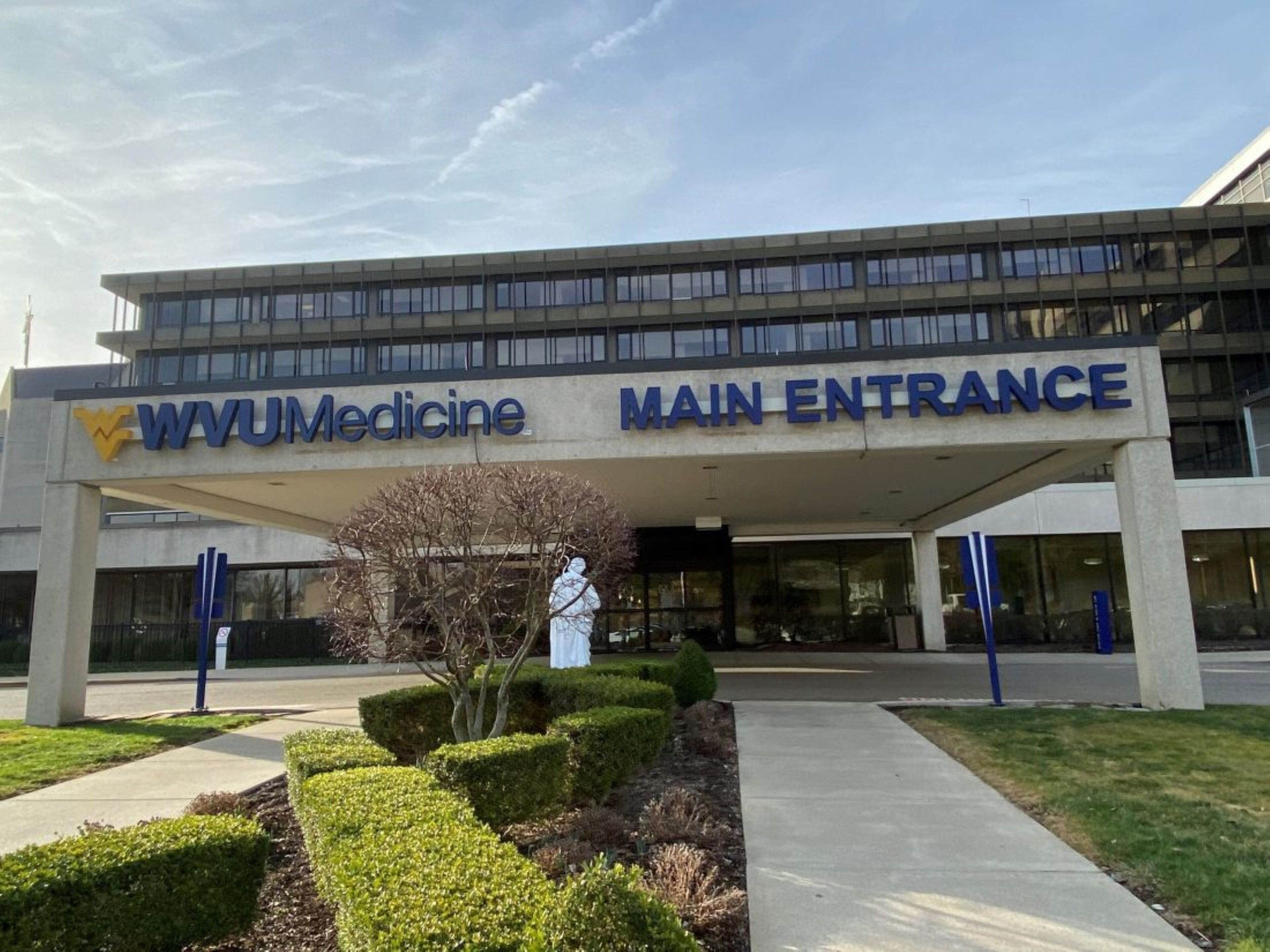 Entrada principal de WVUMedicine con fachada de edificio moderna, señalización clara y jardines bien cuidados.
