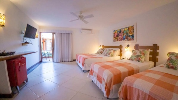 A hotel room with two beds, a desk, a TV, and a ceiling fan. - Azeda Boutique Hotel João Fernandes (Búzios)