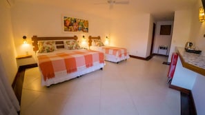 A hotel room with two beds, a painting on the wall, and a kitchenette area. - Azeda Boutique Hotel João Fernandes (Búzios)