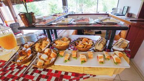 Una mesa de buffet con diversos alimentos y utensilios.