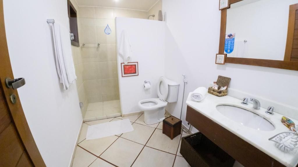 Un baño con inodoro, lavamanos y zona de ducha.