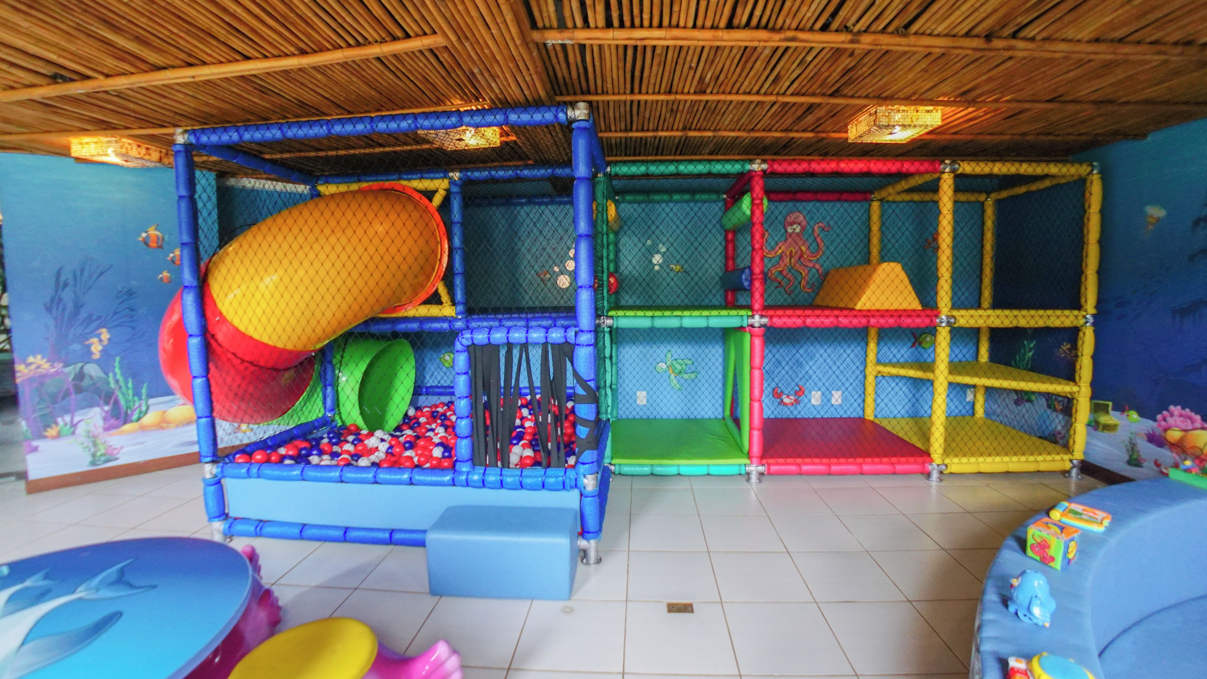 Zona de juegos infantiles con diversas estructuras recreativas y una mesa de billar.
