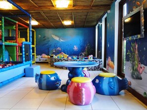 An indoor play area with a pool table, colorful stools, and a mural of an underwater scene. - Azeda Boutique Hotel João Fernandes (Búzios)