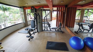 A gym with exercise equipment, a black mat, and blue exercise balls. - Azeda Boutique Hotel João Fernandes (Búzios)