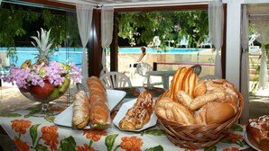 A table with bread, pastries, and a fruit bowl. - Hotel La Foret & Beach Club (Búzios)
