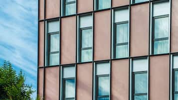 Un edificio moderno con una fachada rosa y una cuadrícula de ventanas.