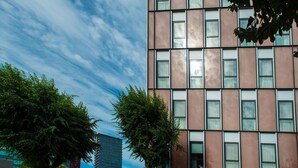 A modern building with a grid of windows and a clear sky. - Ona Living Barcelona (L'Hospitalet de Llobregat)