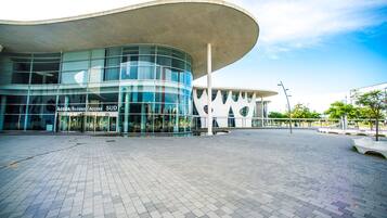 Un bâtiment moderne doté d’une façade en verre incurvée et d’une grande avancée.