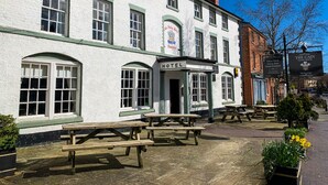 A traditional white building with a sign reading "HOTEL" and outdoor seating. - Cain Valley Hotel (Llanfyllin)