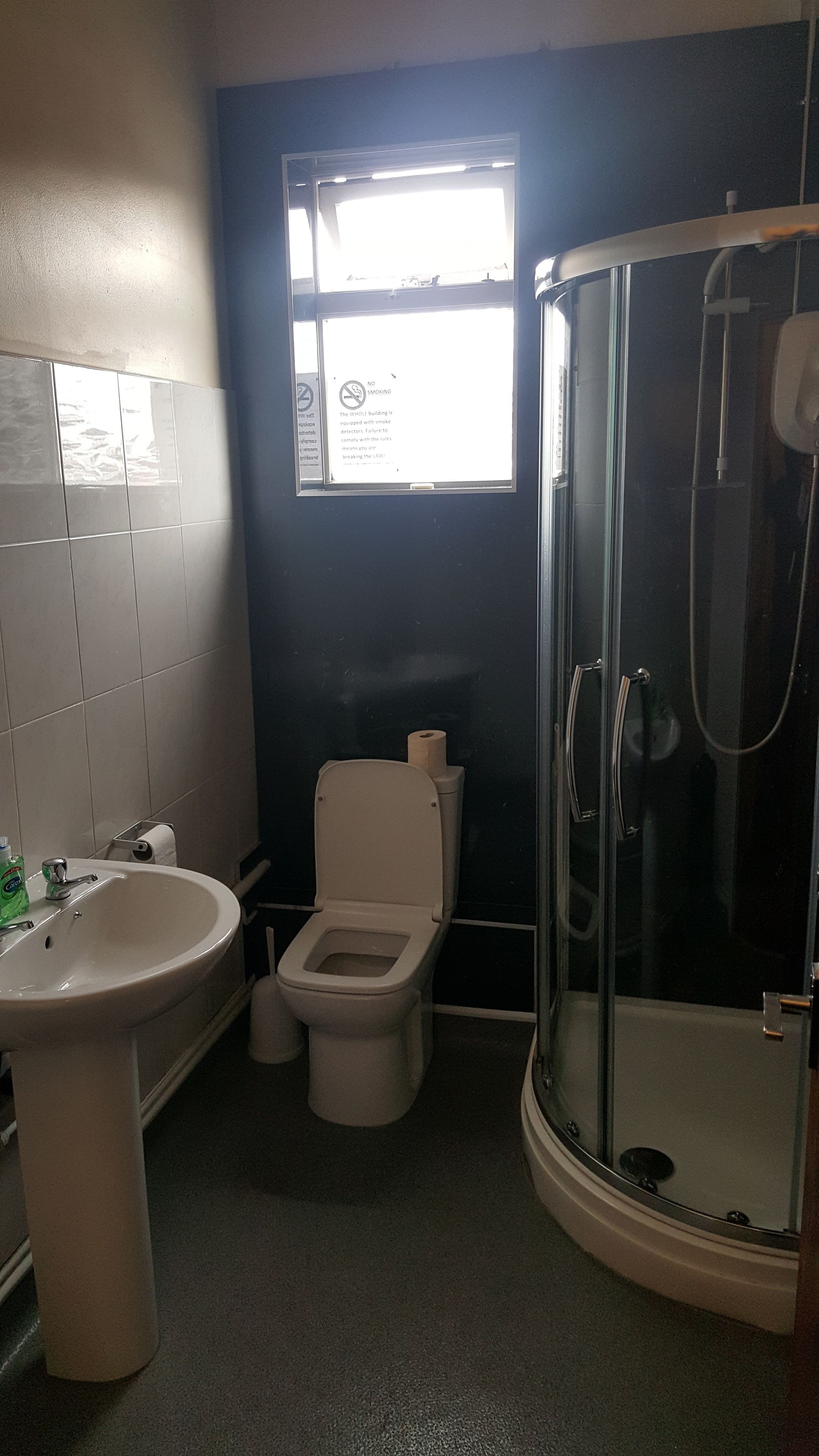 A bathroom with a toilet, sink, and glass-enclosed shower.