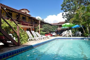 Una piscina al aire libre, sombrillas, tumbonas