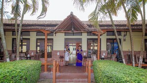 A traditional building with a tiled roof, a central entrance with steps, and potted plants. - Hotel Seven Limited (Sauraha)