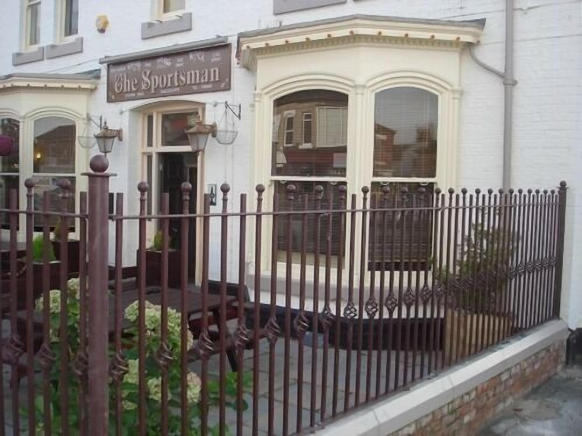 Un bâtiment sur lequel on peut lire l’inscription : « The Sportsman ».