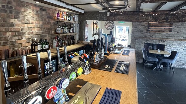 A bar area with wooden bar top, multiple taps, and a Peroni beer tap. - The Swan Hotel (Worcester)