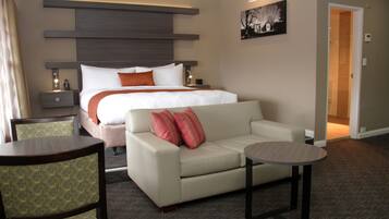 Una habitación de hotel con una cama, un sofá, una mesita y una silla.