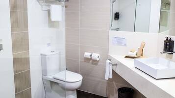 Un baño moderno con inodoro, lavabo y espejo.