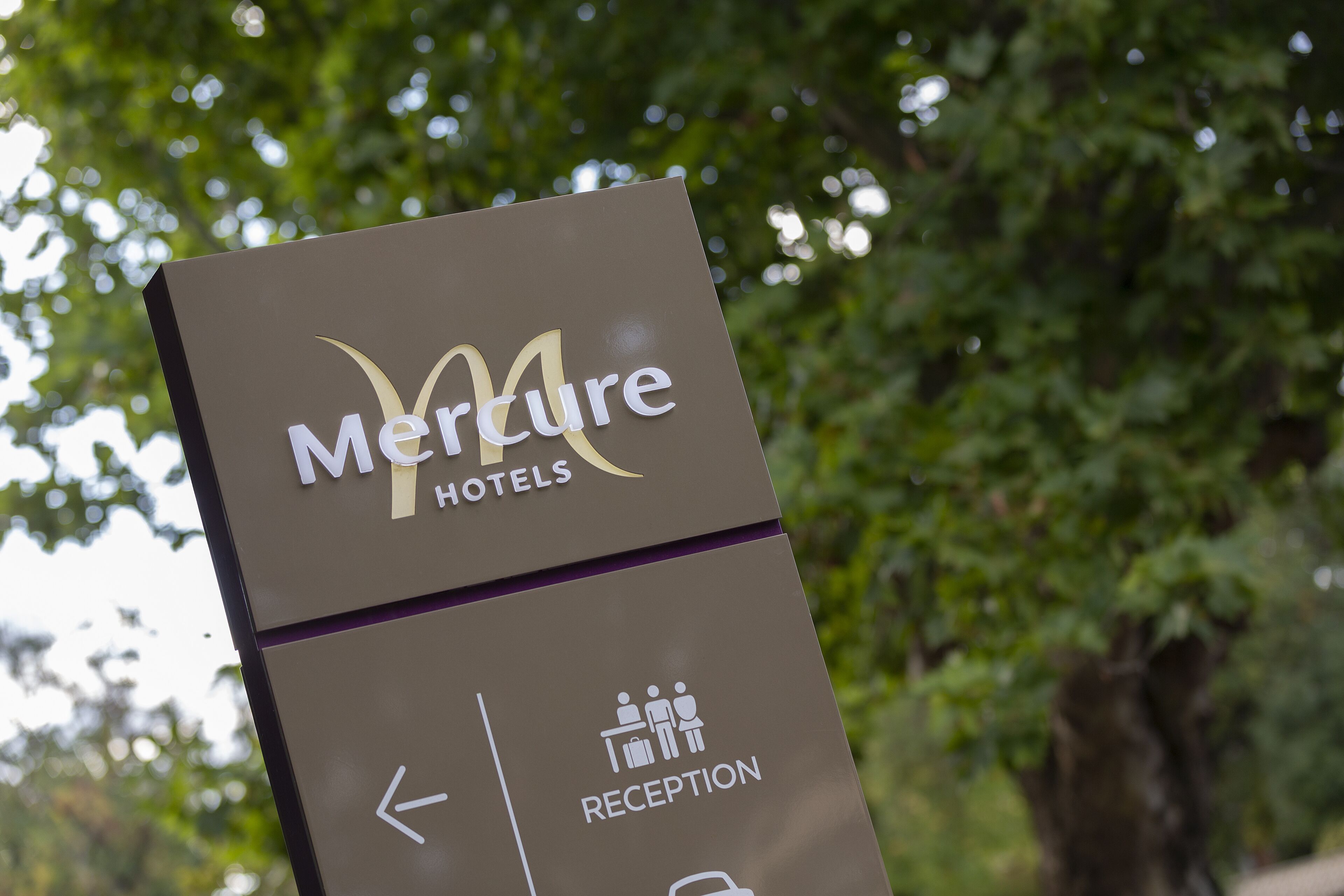 A sign for Mercure Hotels with a reception direction.