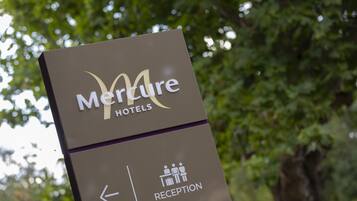 A sign for Mercure Hotels with a reception direction.