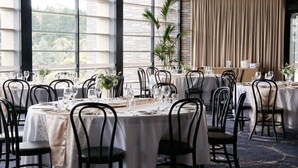 A dining area with round tables, black chairs, and white tablecloths. - Mercure Orange (Orange)