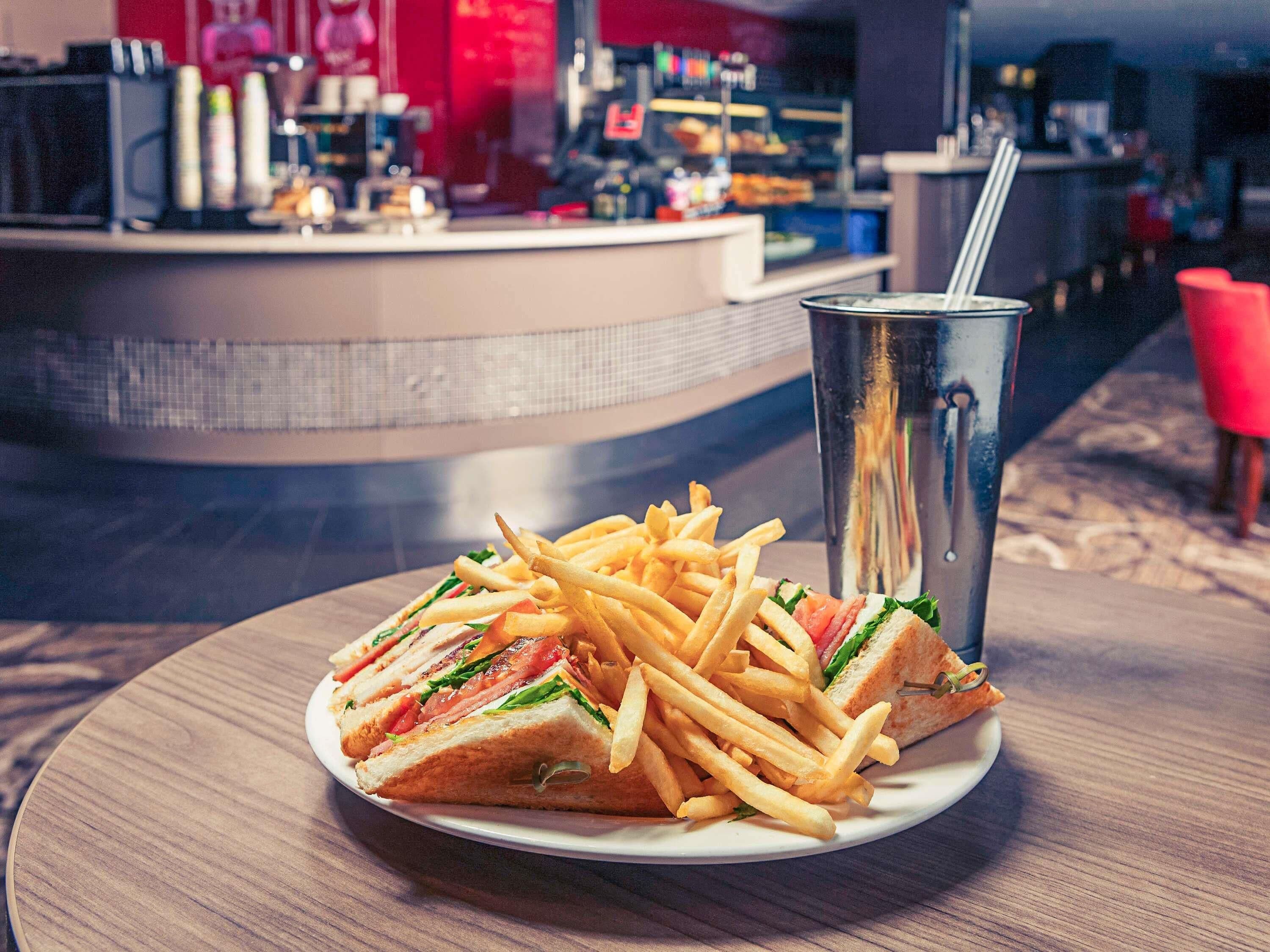 A plate with a sandwich and fries on a table in a restaurant.